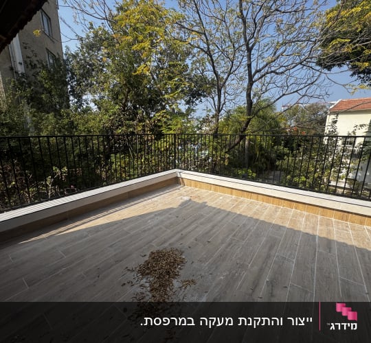 מעקה מתכת שחור עם מוטות אנכיים המותקן במרפסת היקפית